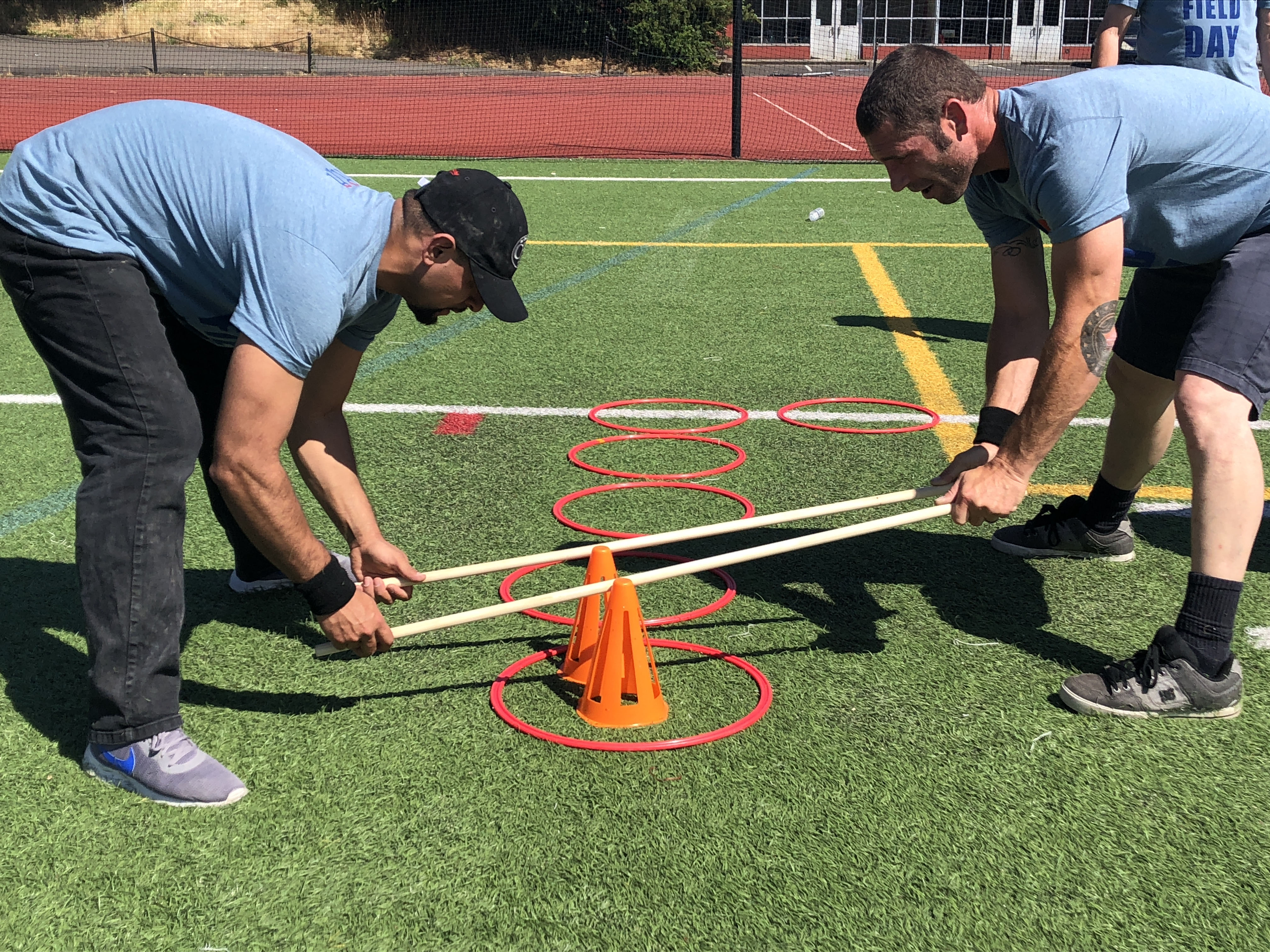 two R&H employees doing field day activities on the football field
